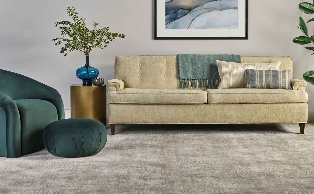 Light brown neutral carpet in living area with tan leather furniture